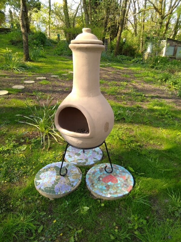 A chiminea in a wooded garden, ready to be lit.